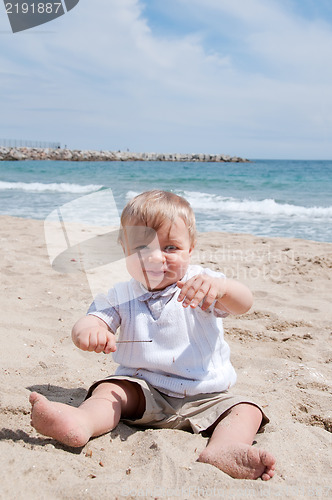 Image of Little boy sitting on the beach