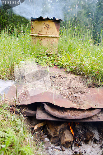 Image of smoke smokehouse rusty barrel firewood burn 