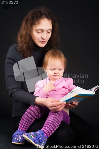 Image of mother with daughter reading book