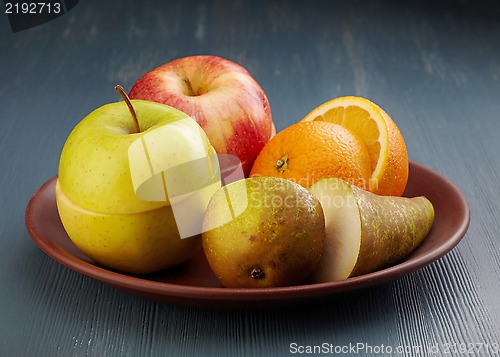 Image of various chopped fruits plate on dark painted wooden table