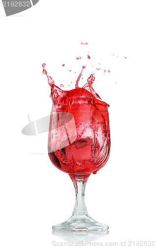 Image of red splashing drink in wine glass