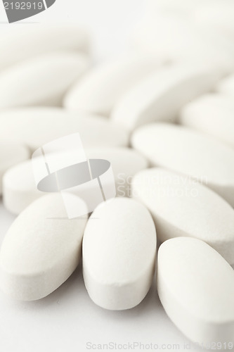 Image of white medical tablets over white