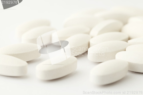 Image of white medical tablets over white