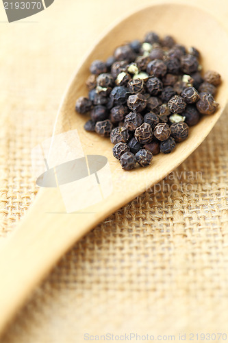 Image of black pepper in wooden spoon