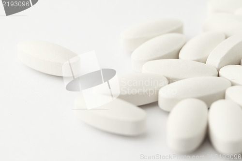 Image of white medical tablets over white
