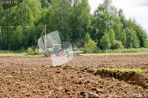 Image of tractor plow agriculture field forest summer 