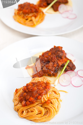 Image of pasta with pork ribbs sauce on polenta bed