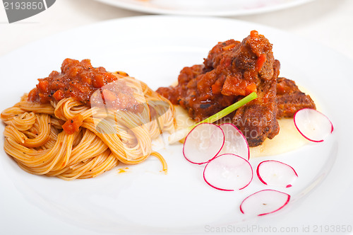 Image of pasta with pork ribbs sauce on polenta bed