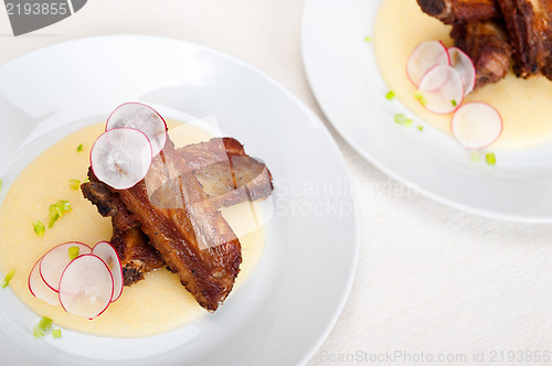 Image of pork ribbs on polenta corn cream bed