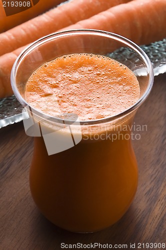Image of carrot juice on a wooden background 