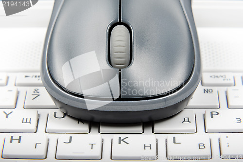 Image of A wireless mouse placed on laptop keyboard