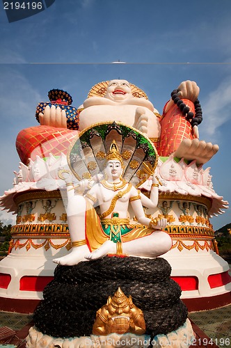 Image of Fat laughing Buddha over blue sky