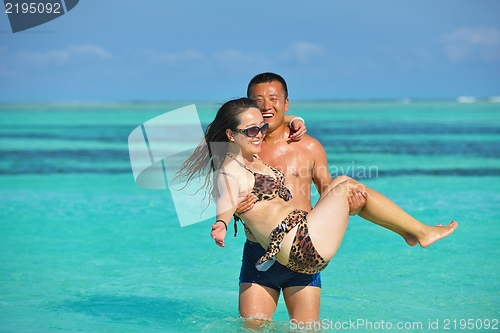 Image of happy young  couple enjoying summer on beach