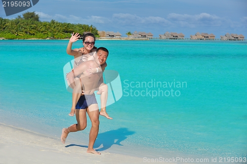 Image of happy young  couple enjoying summer on beach