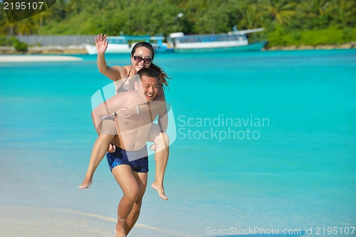 Image of happy young  couple enjoying summer on beach