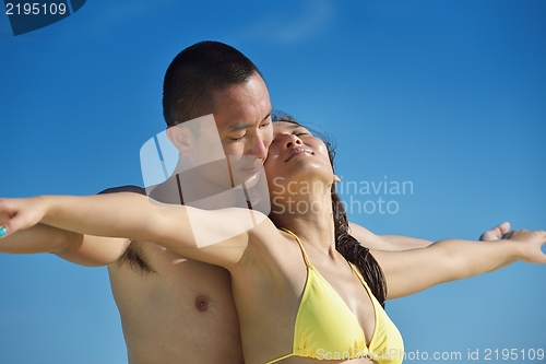 Image of happy young  couple enjoying summer on beach