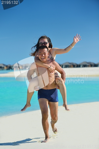Image of happy young  couple enjoying summer on beach