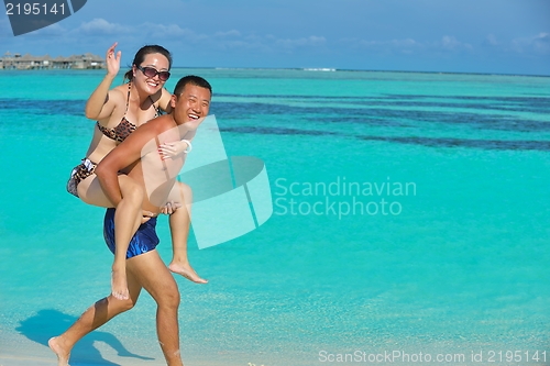 Image of happy young  couple enjoying summer on beach