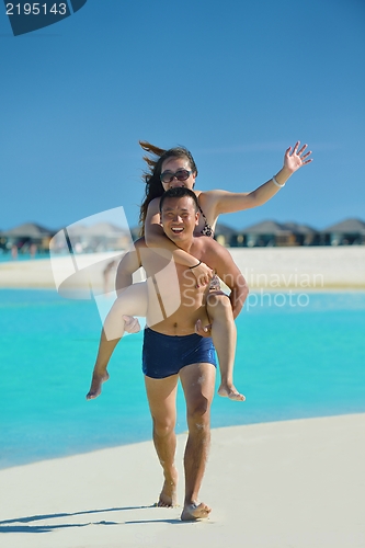 Image of happy young  couple enjoying summer on beach