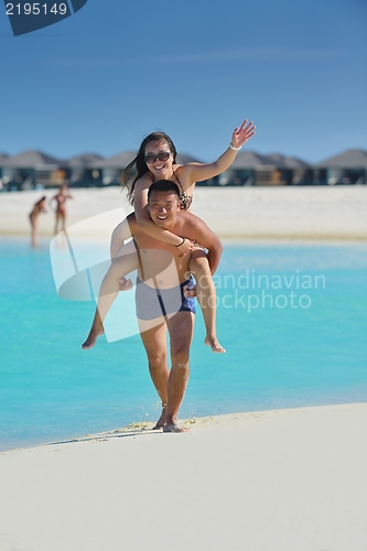 Image of happy young  couple enjoying summer on beach