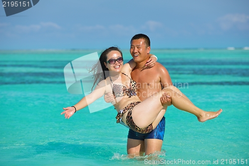 Image of happy young  couple enjoying summer on beach
