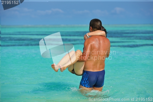 Image of happy young  couple enjoying summer on beach