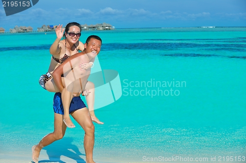 Image of happy young  couple enjoying summer on beach