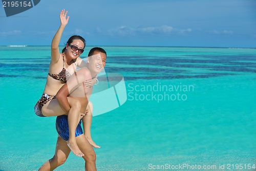 Image of happy young  couple enjoying summer on beach