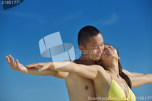 Image of happy young  couple enjoying summer on beach