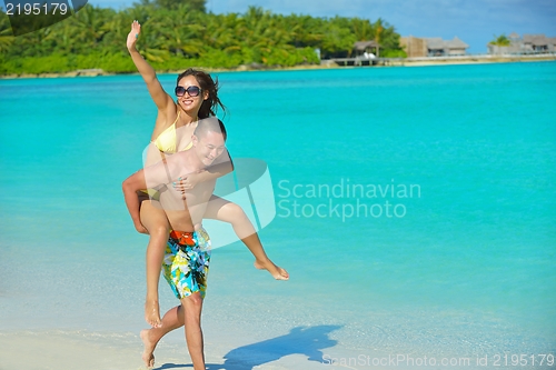 Image of happy young  couple enjoying summer on beach