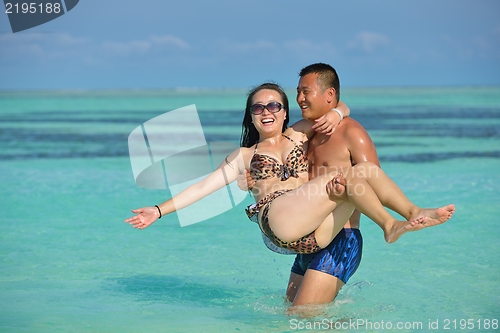 Image of happy young  couple enjoying summer on beach
