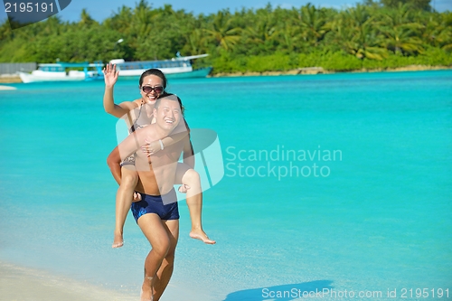 Image of happy young  couple enjoying summer on beach
