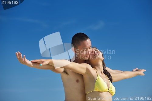 Image of happy young  couple enjoying summer on beach