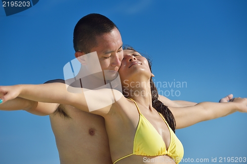 Image of happy young  couple enjoying summer on beach