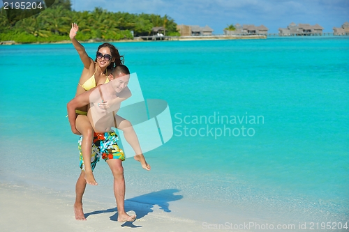 Image of happy young  couple enjoying summer on beach