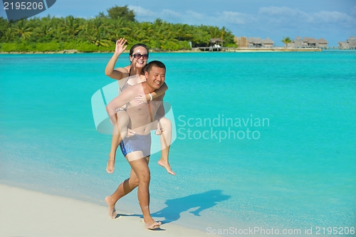 Image of happy young  couple enjoying summer on beach