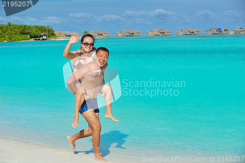 Image of happy young  couple enjoying summer on beach