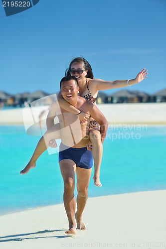 Image of happy young  couple enjoying summer on beach