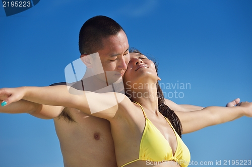 Image of happy young  couple enjoying summer on beach