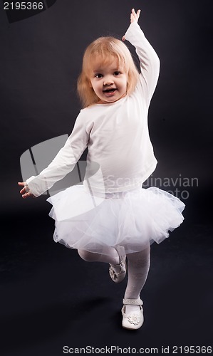 Image of 2 years old girl dancing in white