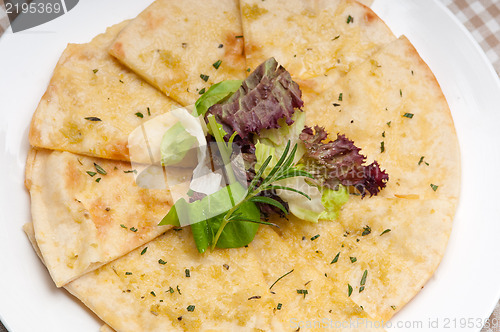 Image of garlic pita bread pizza with salad on top