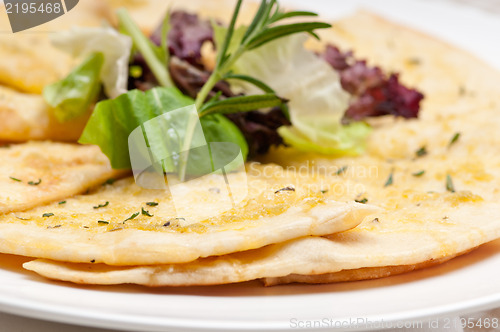 Image of garlic pita bread pizza with salad on top