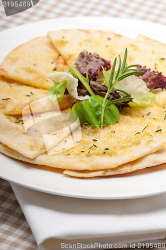 Image of garlic pita bread pizza with salad on top