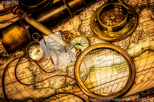 Image of Vintage magnifying glass lies on an ancient world map