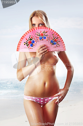 Image of woman with fan on beach