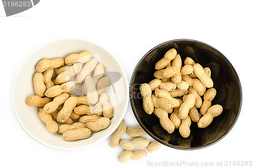 Image of Black and white bowls full of peanuts on a white background