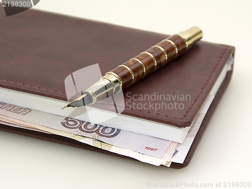 Image of Money inside the diary, and pen