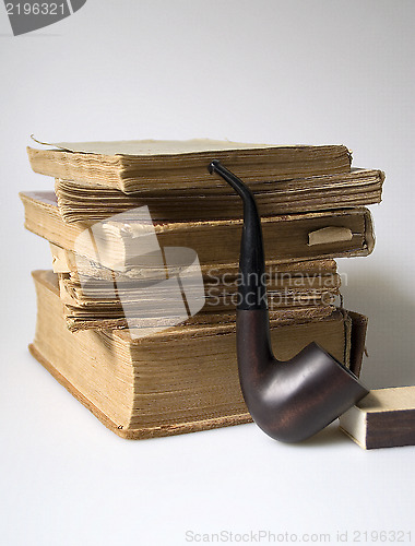 Image of Stack of old books and a pipe