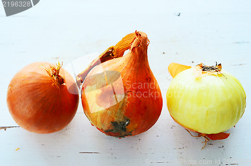 Image of three onions on a white table
