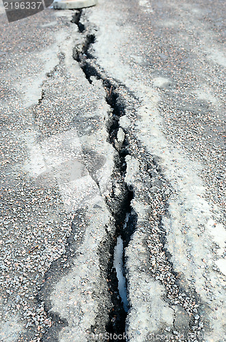 Image of long crack stretching cross the sidewalk 